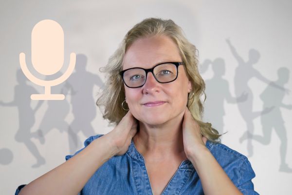 Eine Frau hält sich mit beiden Händen den Nacken.